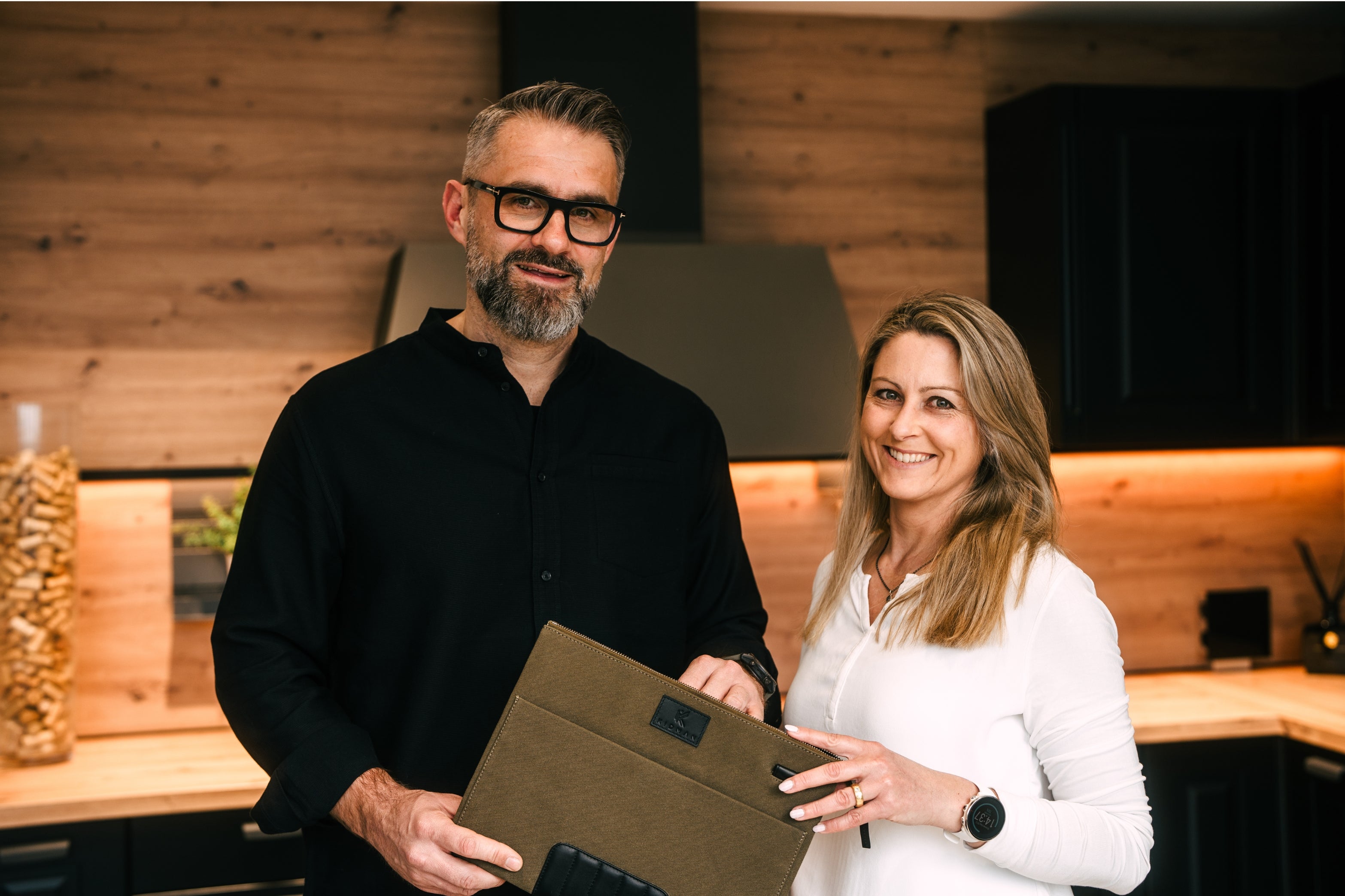 Joachim Schmidt, Gründer und Geschäftsführer, steht mit seiner Frau vor elegantem Hintergrund und hält ein Produkt in Händen. Das Bild symbolisiert Familienverbundenheit und unterstreicht die persönliche Note unseres Unternehmens.